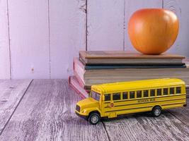 ônibus escolar na mesa de madeira para o conceito de educação foto