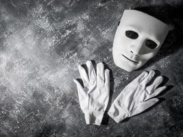 máscara branca com luva em fundo cinza grunge. foto