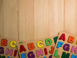 alfabeto de madeira multi cores na mesa para educação ou conceito de criança foto