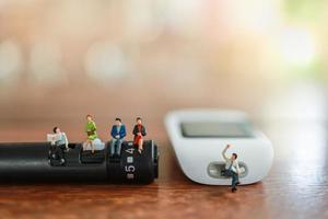 grupo de figura em miniatura de empresário e mulher sentado e falando sobre lanceta e medidor de glicose na mesa de madeira com espaço de cópia usando como medicina, diabetes, glicemia, cuidados de saúde e conceito de pessoas. foto