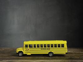 o ônibus escolar na mesa de madeira para voltar às aulas ou conceito de educação foto