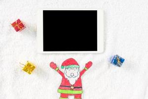 vista superior do papai noel com presentes e tablet em fundo branco. conceito de natal foto