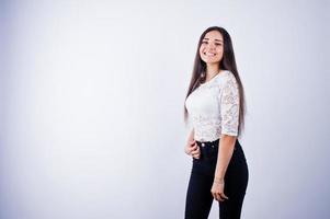 retrato de uma jovem elegante no top branco e calça preta no estúdio. foto