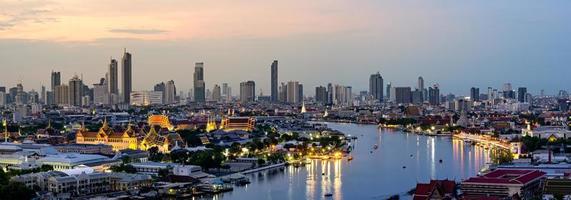 edifício de escritórios alto no centro da cidade de bangkok. ao amanhecer, a luz do céu é azul e laranja. foto