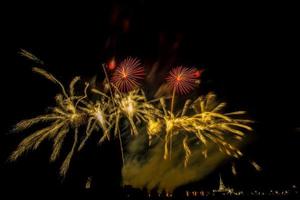 fogos de artifício enormes e coloridos sobre os campos de arroz ao entardecer. foto