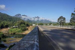 o destino da estrada é uma estrada de montanha nebulosa para a vila de pilok, província de kanchanaburi, tailândia. foto