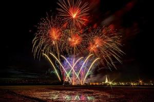 fogos de artifício enormes e coloridos sobre os campos de arroz ao entardecer. foto