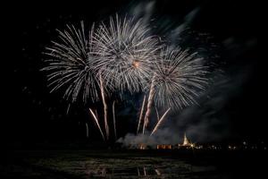 fogos de artifício enormes e coloridos sobre os campos de arroz ao entardecer. foto