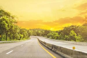 bela estrada da tailândia com montanha verde e fundo de brilho do sol foto