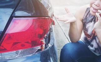 senhora usando telefone chamando agente de seguros para processo de reclamação de acidente de carro foto