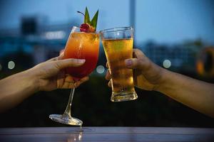 celebração de casal no restaurante com refrigerante cerveja e mai tai ou mai thai - pessoas de estilo de vida feliz com conceito de refrigerante foto