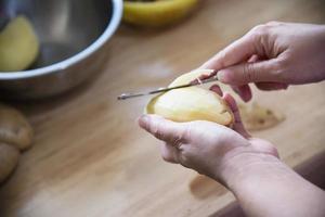 pessoas cozinhando batata fresca preparando comida na cozinha - conceito de cozimento de batata foto