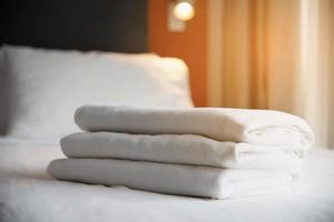 roupa de cama branca e toalha em hotel moderno - férias no conceito de resort hotel foto