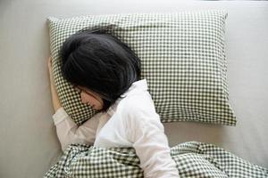 senhora dorme feliz e calma no quarto limpo de manhã - todos os dias no conceito de vida em casa foto