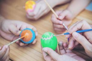 pessoas pintando ovos de páscoa coloridos - conceito de celebração do feriado de páscoa foto