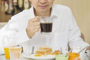 homem de negócios come o café da manhã americano em um hotel - as pessoas tomam um café da manhã no conceito de hotel foto