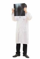 médico masculino em pé examinar filme de raio-x isolado sobre o branco foto