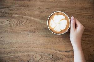 mão segurando uma xícara de café quente - pessoas com conceito de fundo de café foto