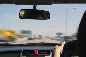 mulher dirigindo carro com as duas mãos foto