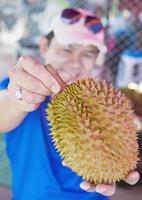 homem mostrando feliz durian maduro foto