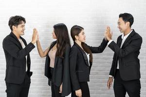 os empresários em pé no fundo da parede branca. grupo de empresários felizes em pose sobre fundo branco foto