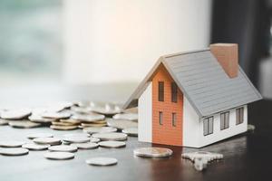 agente imobiliário oferece modelo de casa de mão com chave para cliente e compra ou venda de casa. conceito de empréstimo e seguro de aprovação de empréstimo hipotecário. espaço de cópia