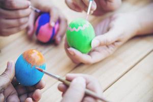 pessoas pintando ovos de páscoa coloridos - conceito de feriado nacional de celebração de pessoas foto