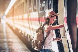 mulher de viagens turísticas olhando para o mapa enquanto caminhava na estação de trem - conceito de viagem de mochila de rua foto