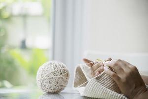 mãos de mulher fazendo trabalho de tricô em casa - pessoas com trabalho diy em casa conceito foto