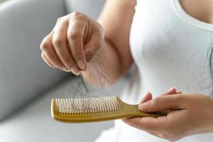 problema de queda de cabelo. mulher asiática com problema de pente e cabelo. perda de cabelo do pente. cuidados com o cabelo e conceitos de beleza. foto