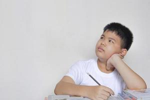 menino asiático leu livros e pensando. criativo, educação, conceito de aprendizagem. foto
