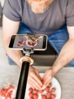 homem preparando almôndegas gravando vídeo smartphone foto