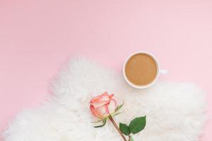 xícara de café e flor rosa em fundo rosa foto
