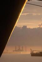 cargueiro e plataforma petrolífera ao nascer do sol foto