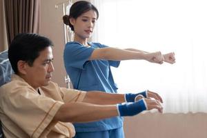 terapeutas de enfermeira asiática esticando os músculos do braço tratamento de fisiológico. foto
