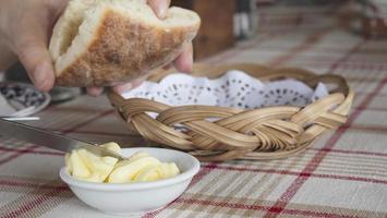 homem comendo pão com aperitivo de manteiga - pessoas com aperitivo de pão servido antes do conceito do prato principal foto