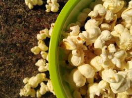 vista alta de pipoca madura servida em bowl.close verde .além de ajudá-lo a perder peso, comer pipoca também tem outros benefícios para a saúde. foto