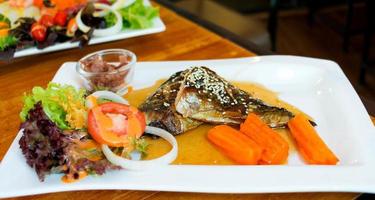 filés de peixe grelhado na chapa branca foto