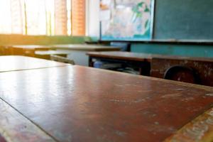 mesa de madeira velha em sala de aula foto