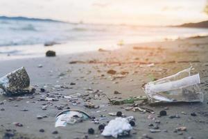 lixo na praia de areia mostrando problema de poluição ambiental foto