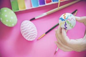 pessoas pintando ovos de páscoa coloridos - conceito de celebração do feriado de páscoa foto