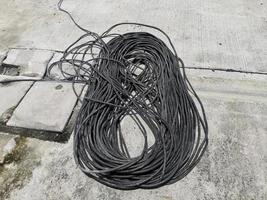 cabo elétrico enrolado preto em um fundo de superfície de estrada foto