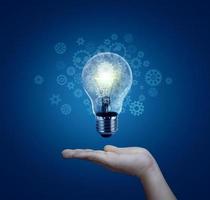 lâmpada na mão, novas ideias com tecnologia inovadora e criatividade. ideia criativa com lâmpadas cintilantes foto
