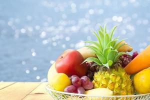 frutas na mesa de madeira e fundo da piscina foto