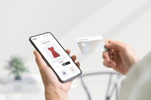 compras on-line com o conceito de telefone inteligente e cartão de crédito. página da web de comércio eletrônico moderno com roupas femininas
