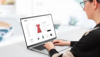 mulher compras on-line com laptop. conceito de comprar roupas femininas online em sites de comércio eletrônico