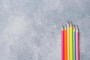 lápis de cor brilhante na mesa cinza. escola de conceito. espaço de cópia foto