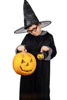 criança se veste de mago segurando jack o lanterna alegremente para o festival de halloween foto
