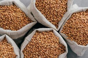 pequenos sacos de linho cheios de trigo mourisco cru para uma alimentação saudável. agricultura e lavoura. trigo sarraceno cru. produto dietético