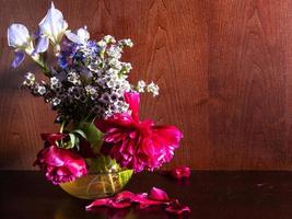 flores murchas em vaso em fundo marrom escuro foto